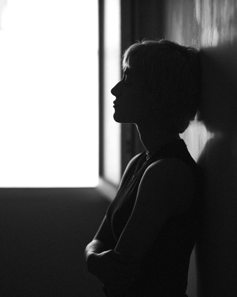Silhouette of a woman in soft window light, reflecting
